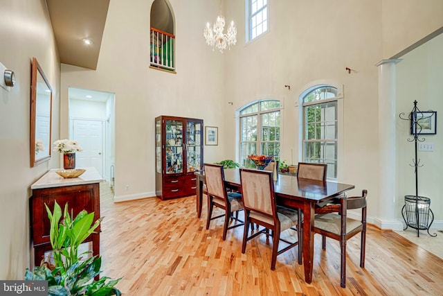 dining space with an inviting chandelier, light wood-style flooring, and a wealth of natural light