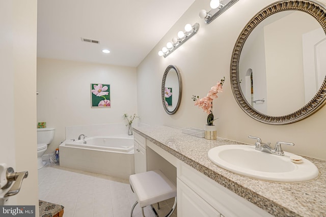 bathroom with a garden tub, visible vents, toilet, vanity, and tile patterned floors