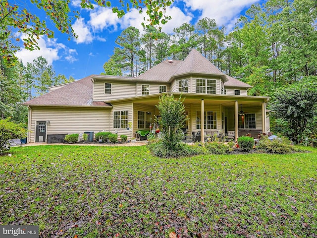 exterior space featuring roof with shingles, a lawn, and a patio area