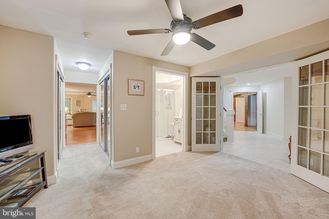 interior space with ceiling fan, baseboards, and french doors