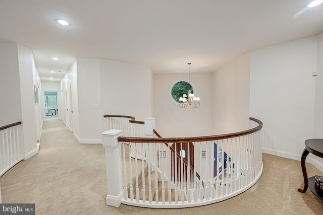 corridor featuring carpet floors, recessed lighting, baseboards, and an upstairs landing