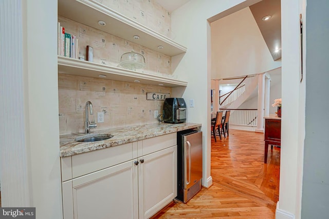 bar with decorative backsplash, wine cooler, stairs, parquet flooring, and a sink