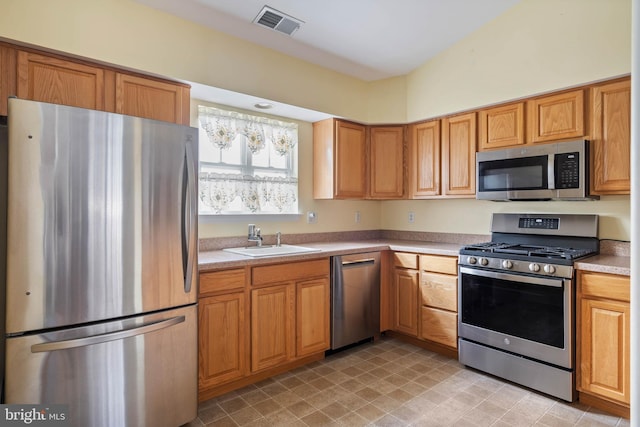 kitchen with visible vents, appliances with stainless steel finishes, light countertops, and a sink