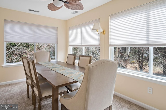 carpeted dining room featuring a ceiling fan, visible vents, and baseboards