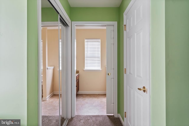 hallway with carpet and baseboards