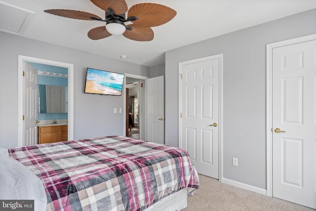 bedroom with light carpet, connected bathroom, a sink, ceiling fan, and baseboards