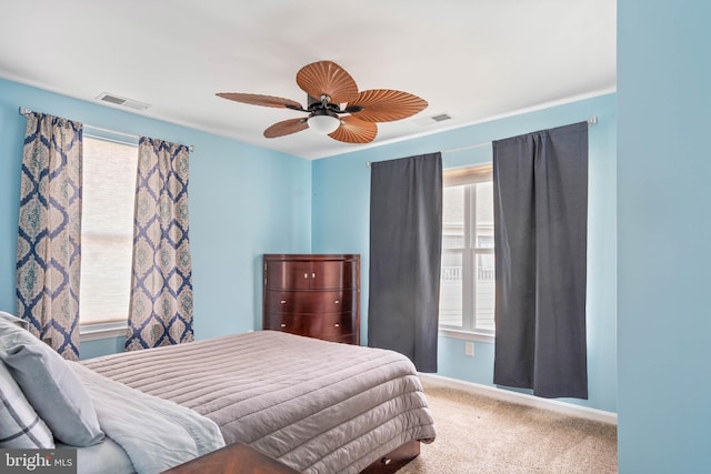 carpeted bedroom featuring baseboards, visible vents, and a ceiling fan