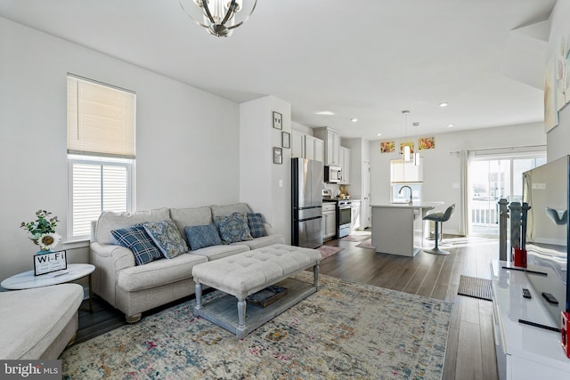 living area with dark wood-type flooring and recessed lighting