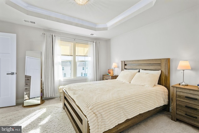 bedroom with light carpet, ornamental molding, a raised ceiling, and visible vents