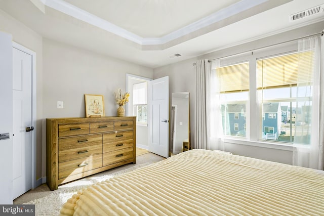 bedroom with baseboards, a raised ceiling, visible vents, and crown molding