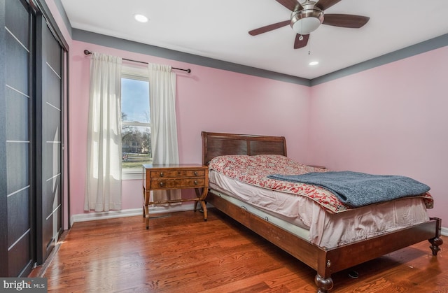 bedroom featuring a ceiling fan, baseboards, wood finished floors, and recessed lighting