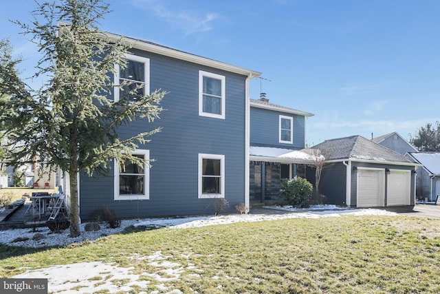 traditional-style home featuring a garage, a yard, and driveway