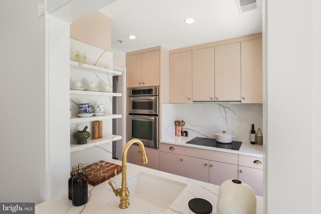 kitchen with visible vents, cream cabinets, stainless steel double oven, and black electric cooktop