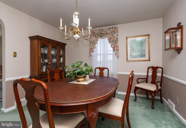 dining space featuring arched walkways, carpet flooring, baseboards, and an inviting chandelier