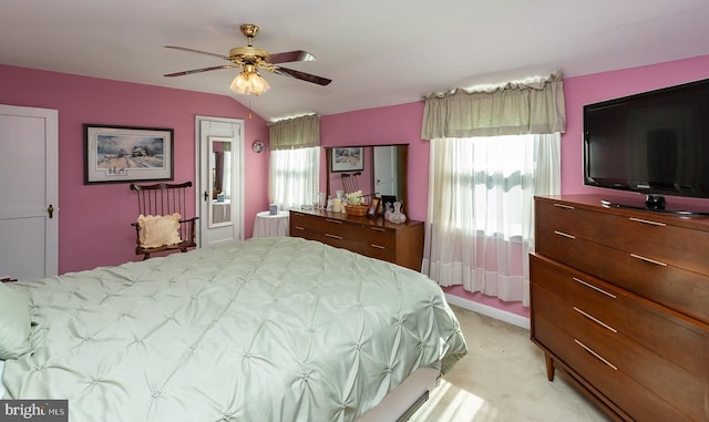 bedroom with light carpet, ceiling fan, multiple windows, and vaulted ceiling