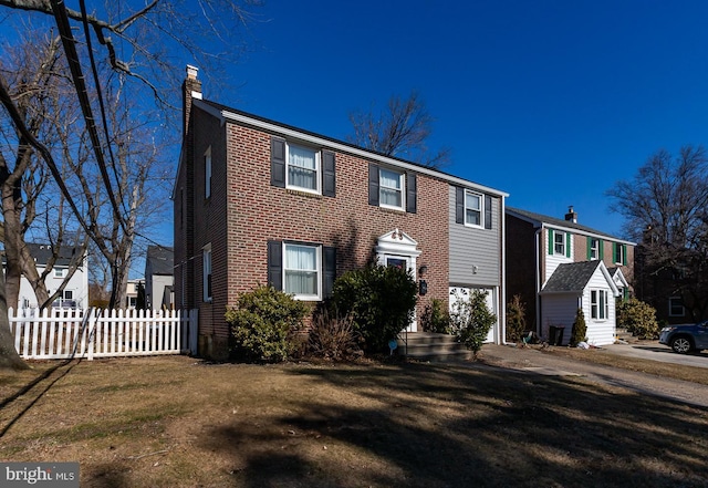 colonial-style house featuring brick siding, fence, a chimney, and a front lawn