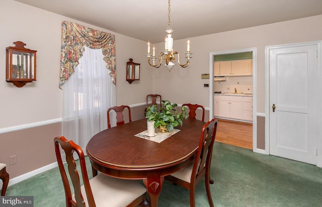 dining area featuring a chandelier, dark carpet, and baseboards