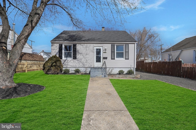 view of front facade featuring a front yard, fence, and a chimney