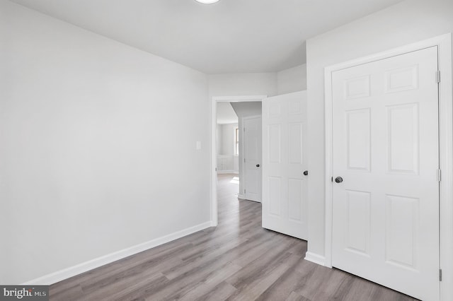 unfurnished bedroom featuring baseboards and wood finished floors