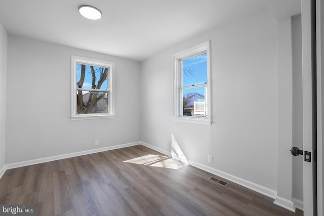 interior space featuring a wealth of natural light, dark wood-style flooring, visible vents, and baseboards