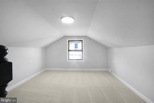 bonus room featuring vaulted ceiling, carpet, and baseboards