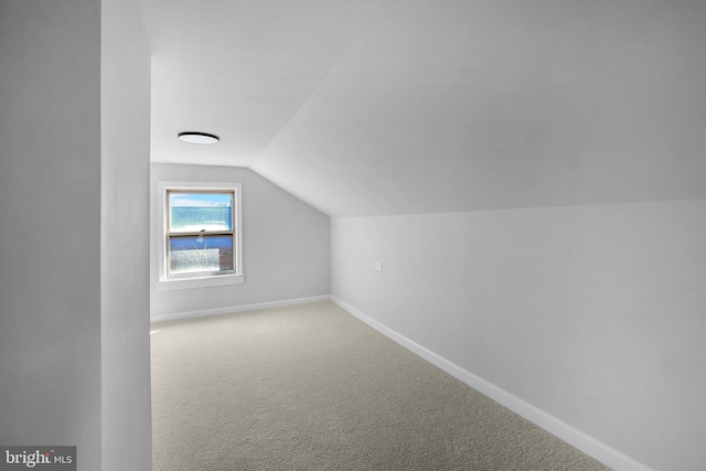 bonus room with vaulted ceiling, carpet floors, and baseboards