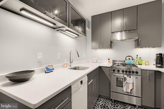 kitchen with gray cabinetry, high end stainless steel range, white dishwasher, and under cabinet range hood