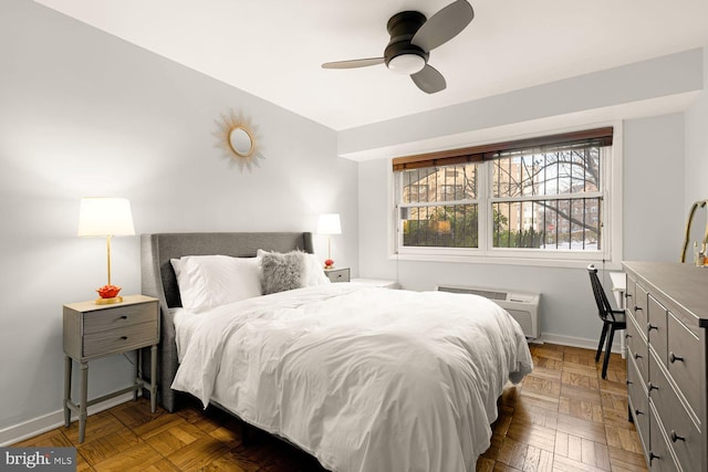 bedroom with baseboards, a ceiling fan, and a wall mounted air conditioner