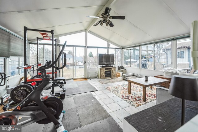 sunroom / solarium featuring lofted ceiling with beams, plenty of natural light, and a ceiling fan