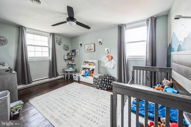 bedroom featuring dark wood-style floors, a baseboard radiator, and ceiling fan