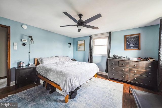 bedroom with dark wood finished floors, baseboards, and ceiling fan