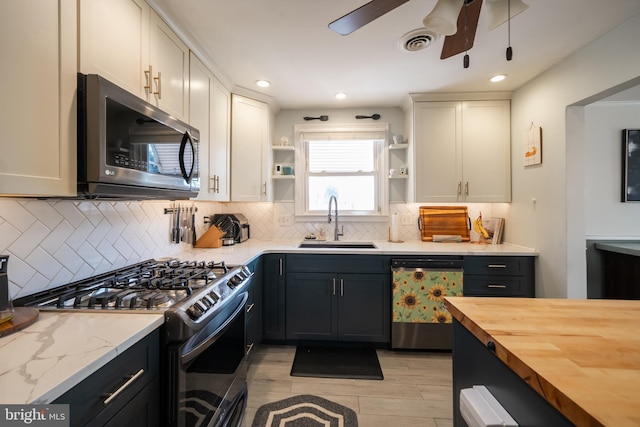 kitchen featuring butcher block counters, a sink, visible vents, appliances with stainless steel finishes, and open shelves