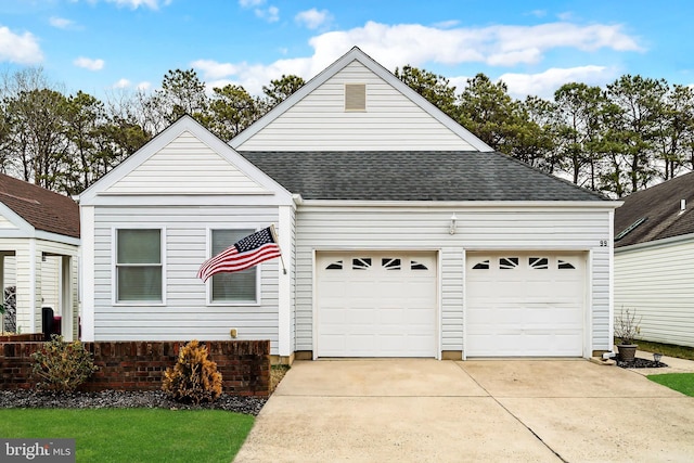 traditional-style home with a shingled roof, driveway, and an attached garage