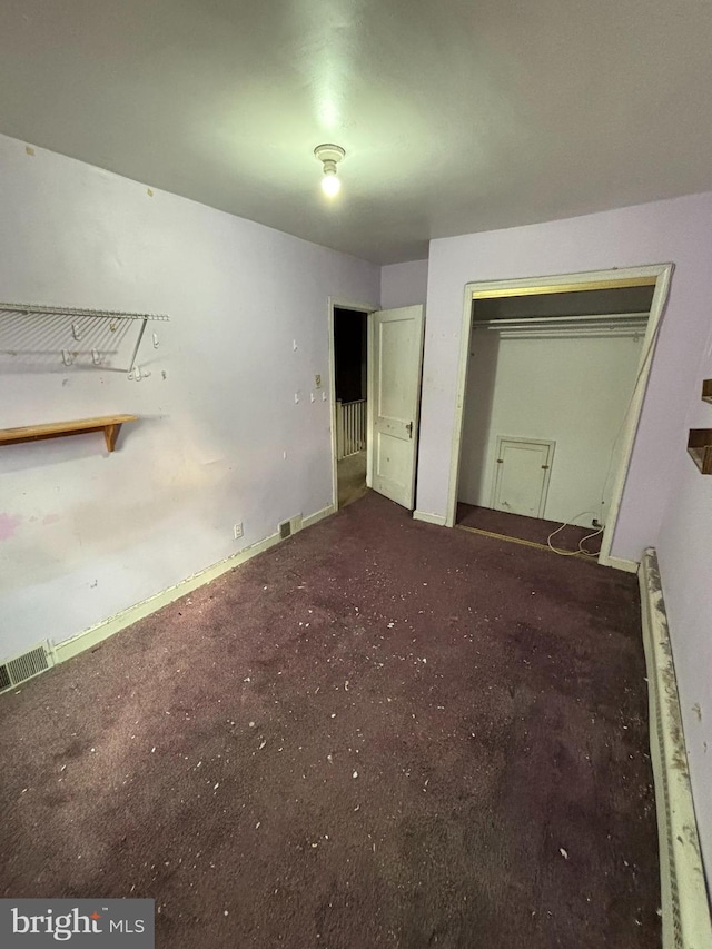 unfurnished bedroom featuring baseboards, carpet, visible vents, and a closet