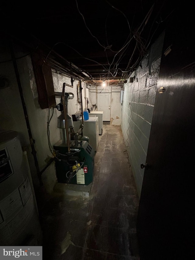 unfinished basement featuring washing machine and dryer, water heater, and a heating unit