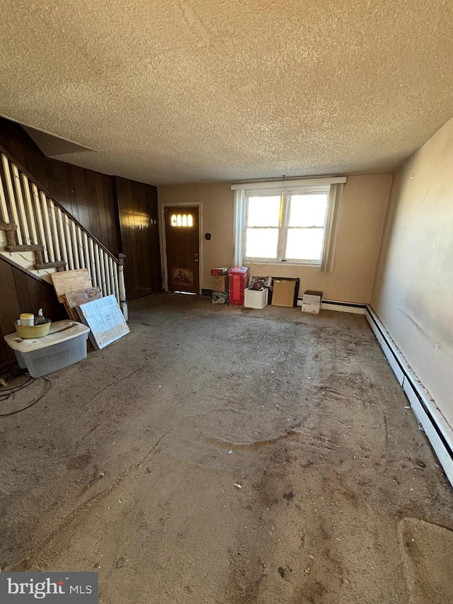 unfurnished living room with stairway and a textured ceiling