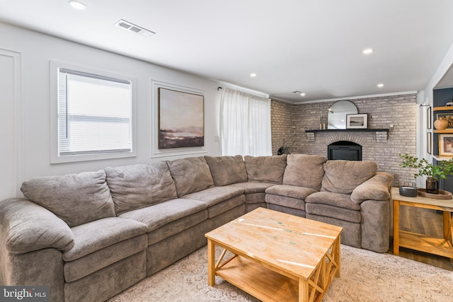 living room featuring recessed lighting, visible vents, a fireplace, and brick wall