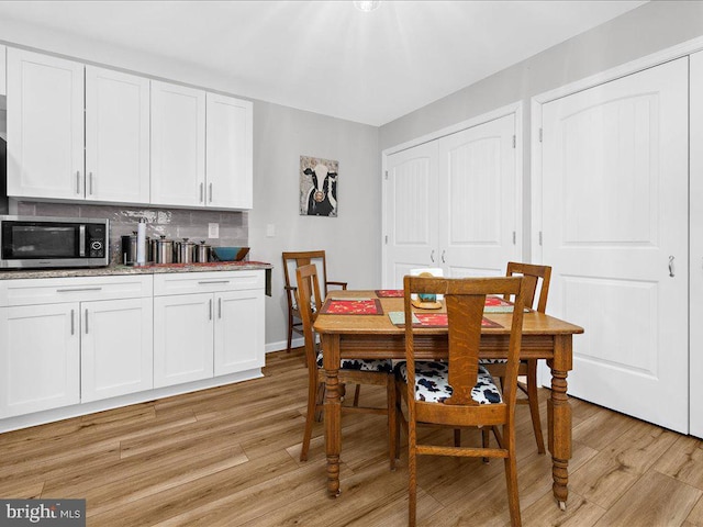 dining area featuring light wood finished floors and baseboards