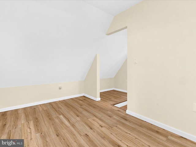 bonus room with baseboards, vaulted ceiling, and wood finished floors