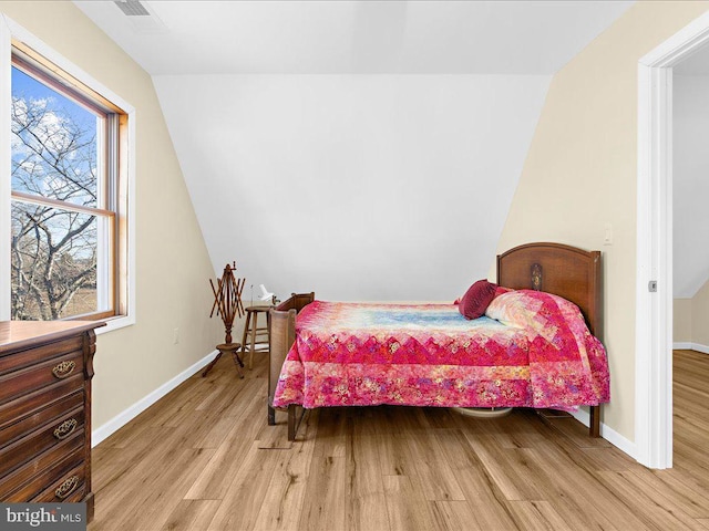 bedroom with light wood-type flooring, visible vents, and baseboards