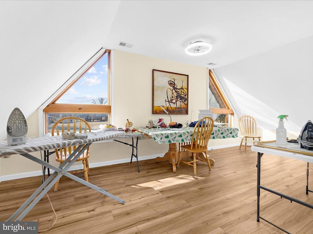 interior space featuring lofted ceiling, baseboards, visible vents, and wood finished floors