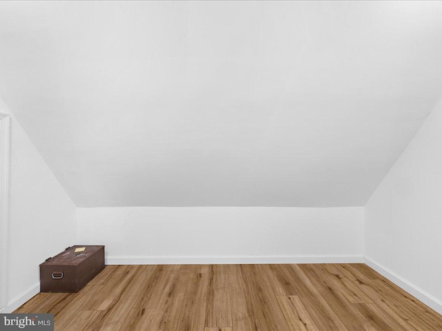 bonus room with lofted ceiling, baseboards, and wood finished floors