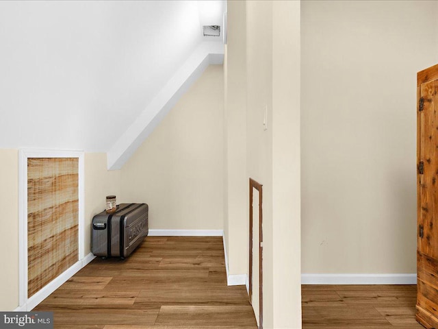 additional living space with baseboards, vaulted ceiling, and wood finished floors