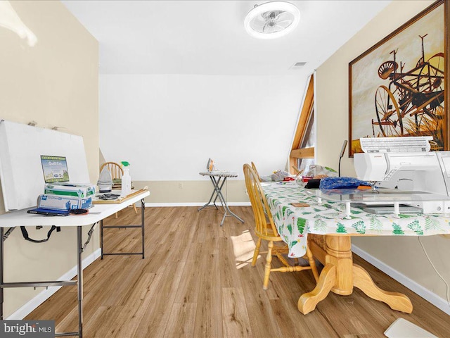 dining space with visible vents, baseboards, and wood finished floors