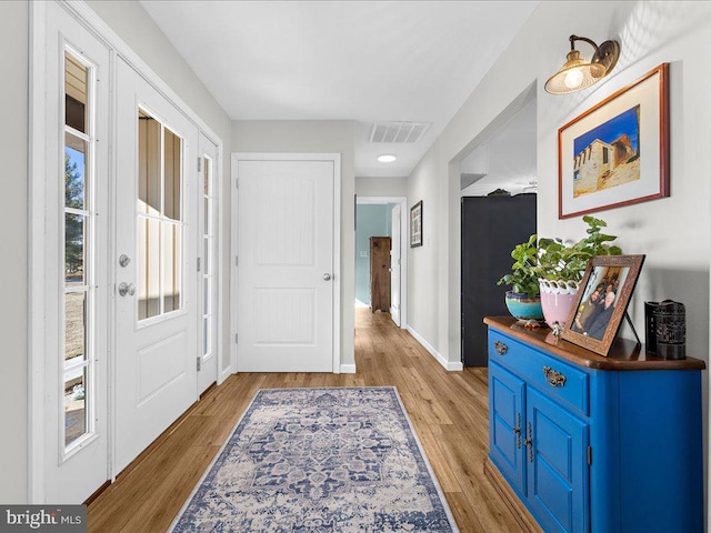 foyer featuring baseboards, visible vents, and light wood-style floors