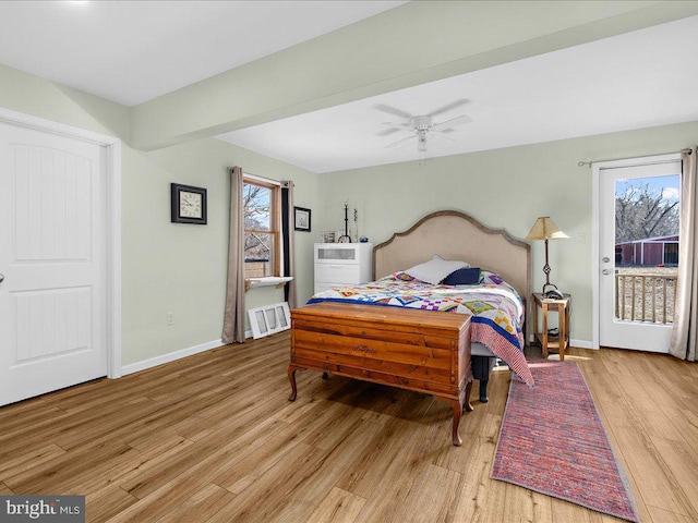 bedroom featuring light wood-style floors, access to exterior, multiple windows, and baseboards