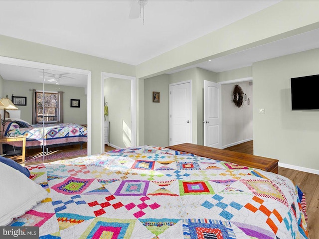 bedroom featuring ceiling fan, a closet, baseboards, and wood finished floors