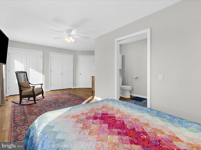 bedroom with multiple closets, a ceiling fan, baseboards, and wood finished floors