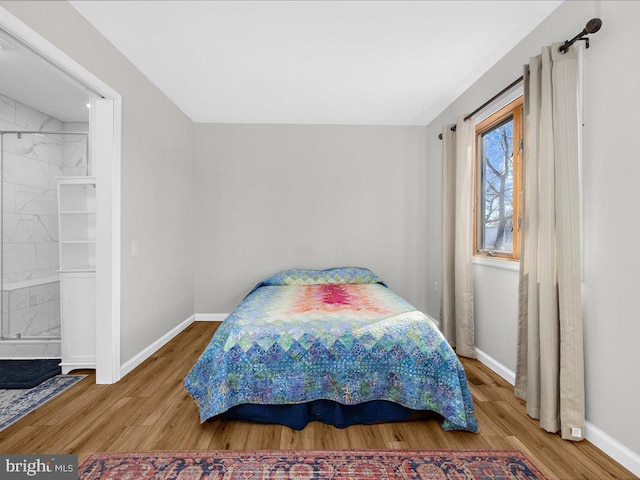 bedroom featuring wood finished floors and baseboards