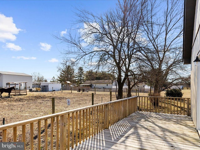 deck featuring an outbuilding and fence